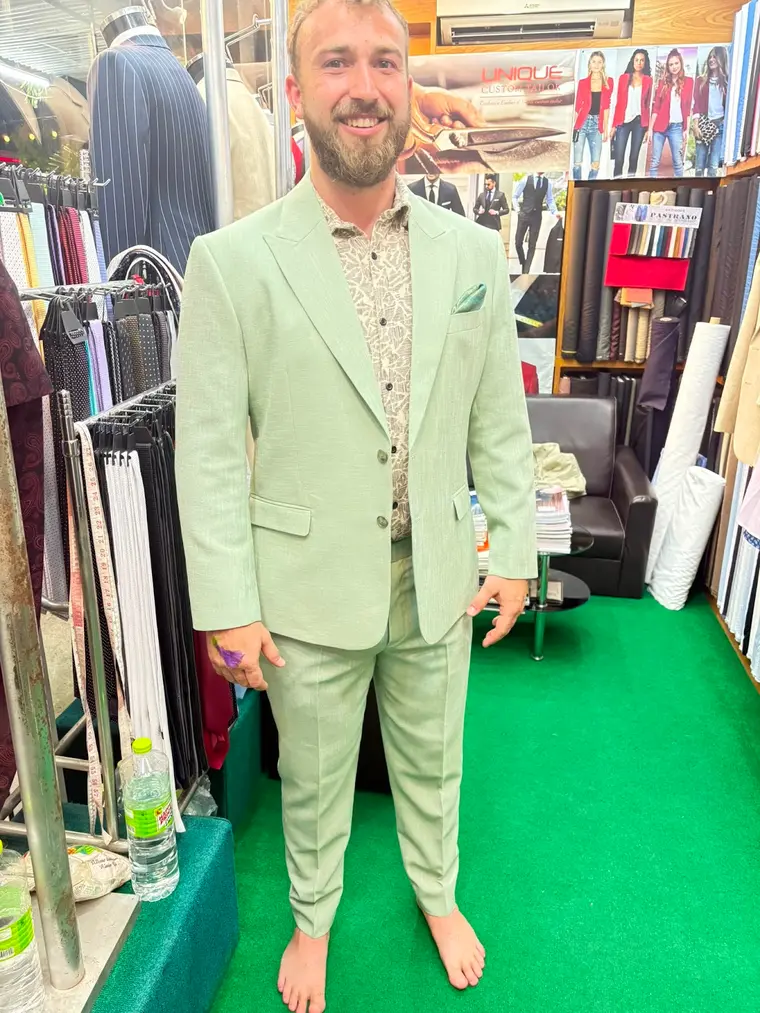 Client in a sage-green linen suit made by Unique Custom Tailor